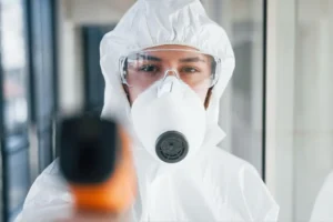 Mold in an Apartment - A Mold Remediation Tech Wearing a Full Body Protective Suit Looking Seriously Into the Camera.