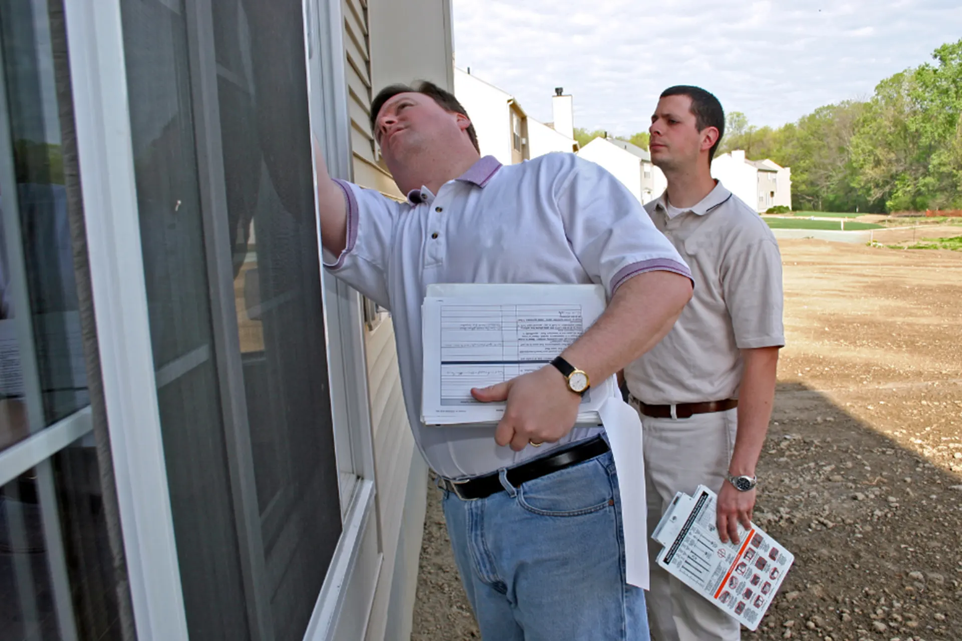 Basement Mold Remediation Services for New York - Two Mold Inspectors Inspecting the Outside of a Home for Mold