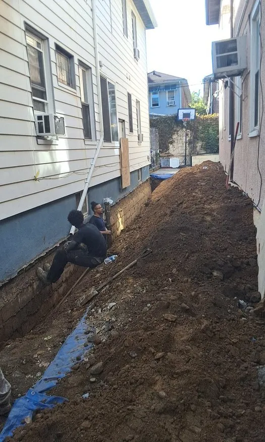 Exterior Drainage Solutions - Workers Installing a Footing Drainage System